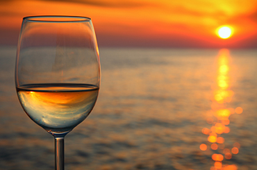 White wine by the water with sunset reflections